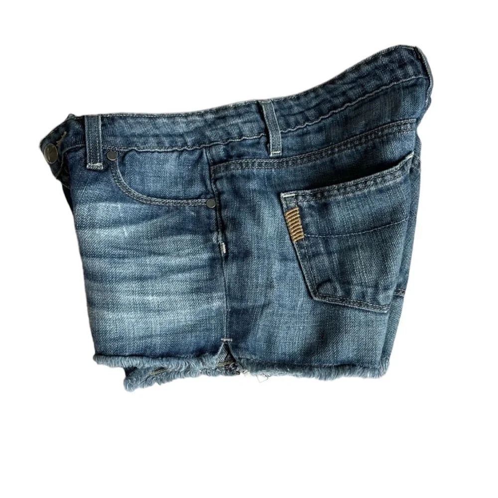 PAIGE Medium Wash Cut Off Raw Hem Jeans Shorts